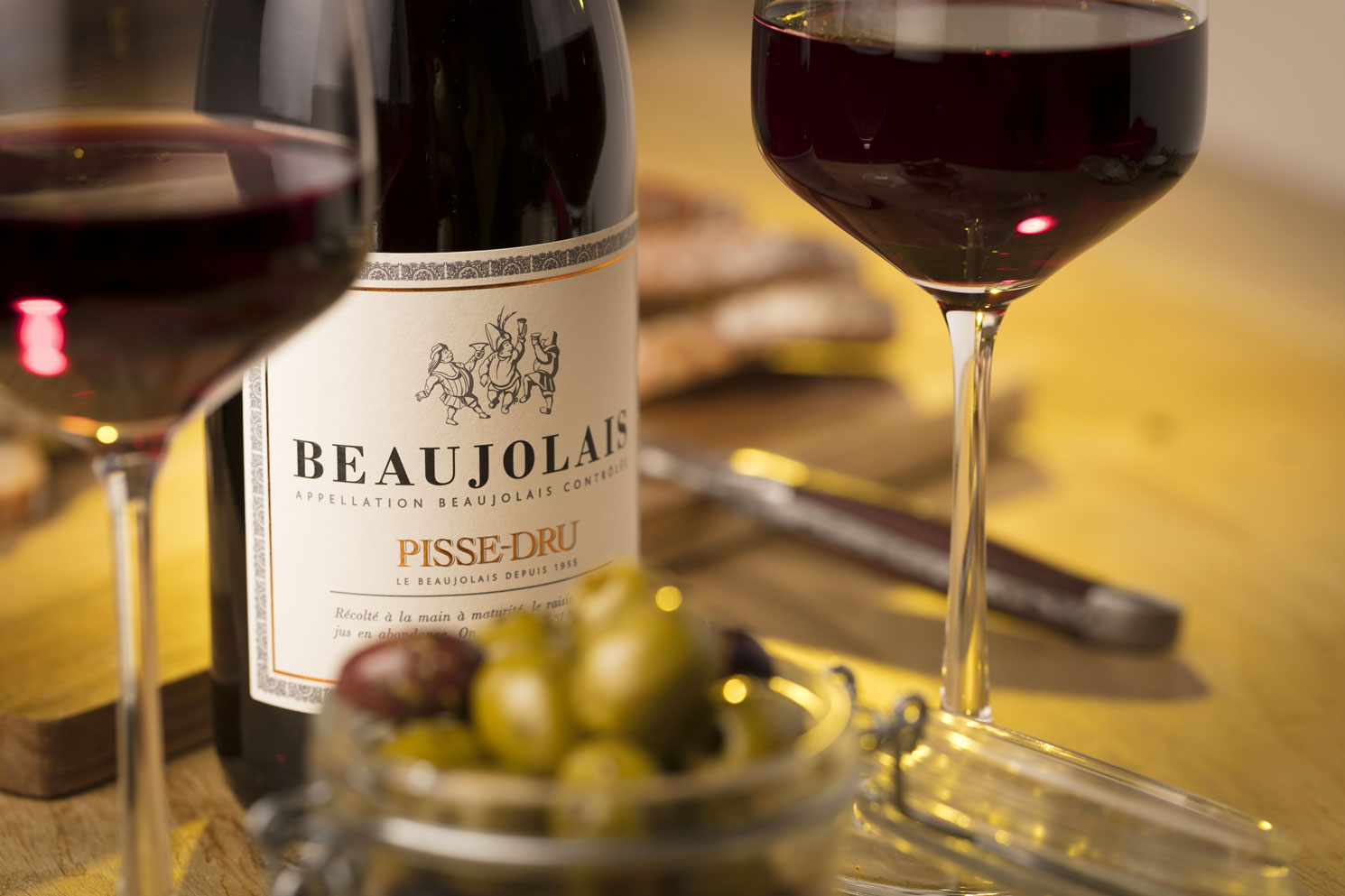 Beaujolais Pisse-Dru Moulin à vent accompagné d'un pot d'olives vertes en plan sérré